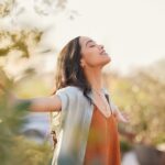 Young,Latin,Woman,With,Arms,Outstretched,Breathing,In,Fresh,Air